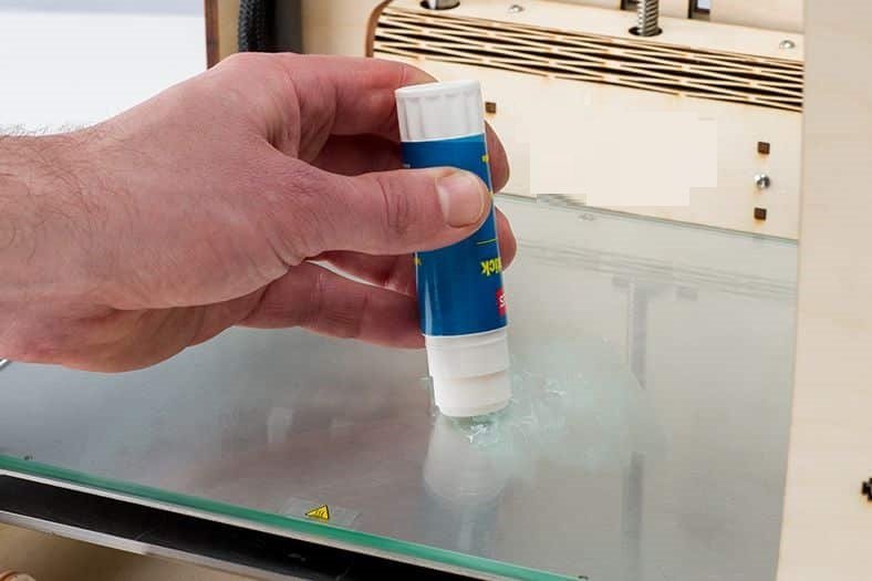 Using adhesive in a print bed